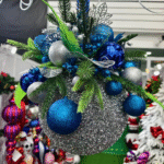 Blue and silver glitter hanging Christmas ball arrangement with greenery for commercial holiday displays.